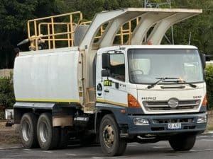A white Hino FM 500 water truck for mining is parked on an asphalt surface.